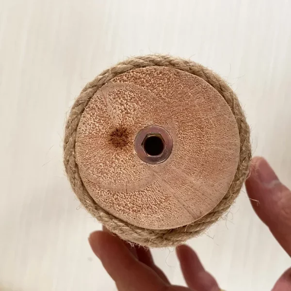 Side view of a solid wood cat scratching post with sisal rope, showing its cylindrical shape.