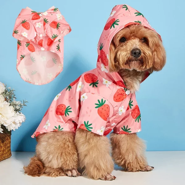 Close-up of the pink dog raincoat fabric showing the detailed strawberry print and texture.