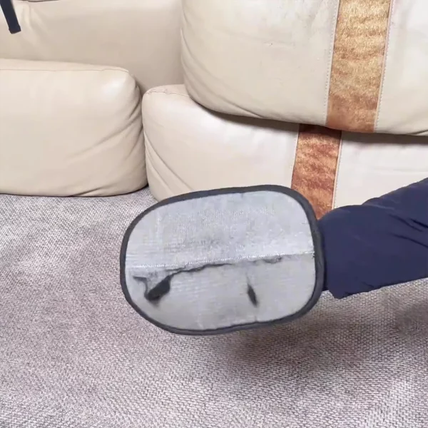 Pet hair remover mitt cleaning pet hair from a sofa