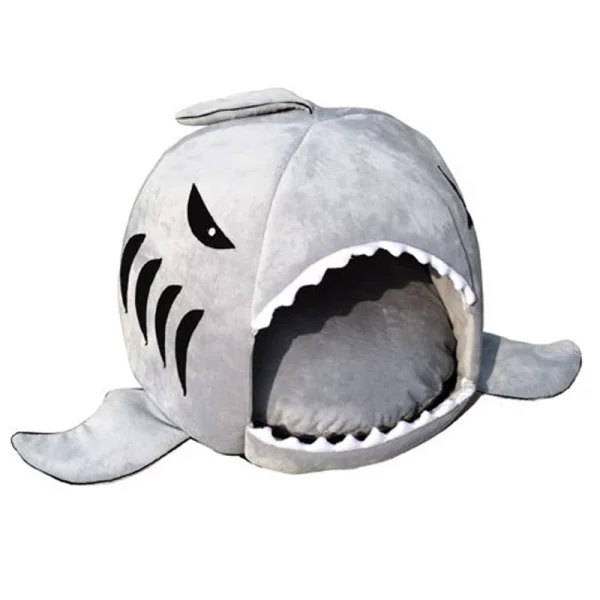 A cat or small dog resting inside the shark pet house.